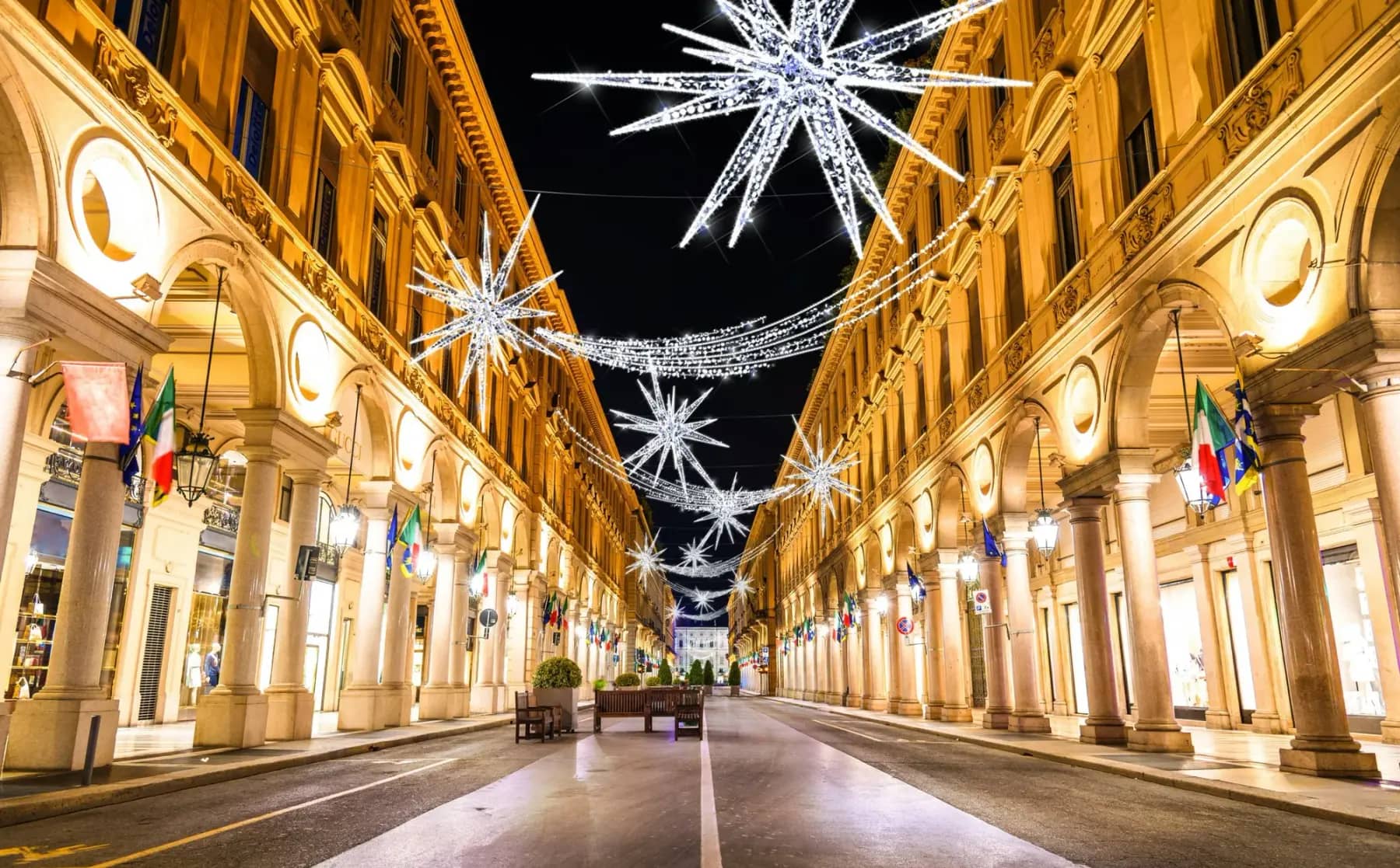 Illuminated commercial Christmas star displays over a decorated downtown street at night