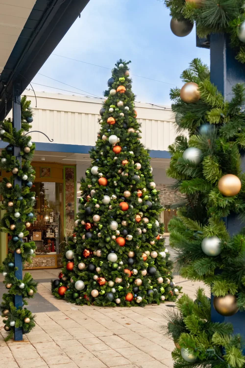 Giant commercial Christmas tree lighting a downtown square at night